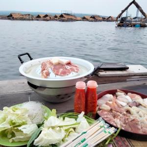 a table with a bowl of food next to the water at บ้านสวนริมน้ำวังใหญ่ ห้อง a1 วังสามหมอ อุดรธานี in Ban Tha Ngam
