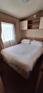 a bedroom with a large white bed with a window at NB166 - Porth Bay Hideaway in Newquay Bay Resort