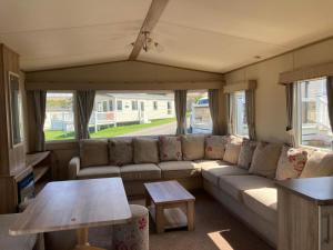 a living room with a couch and a table at NB166 - Porth Bay Hideaway in Newquay Bay Resort