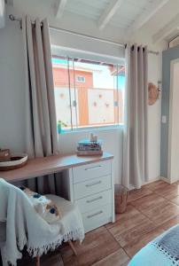 a bedroom with a desk and a window at Casa com piscina climatizada em frente à Praia do Santinho in Florianópolis