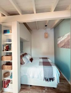 1 dormitorio con cama y estante para libros en Casa com piscina climatizada em frente à Praia do Santinho, en Florianópolis