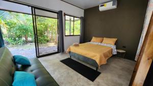 a bedroom with a bed and a couch at DS House in Cabuya