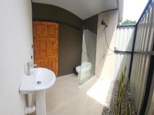 a bathroom with a sink and a window and a door at DS House in Cabuya