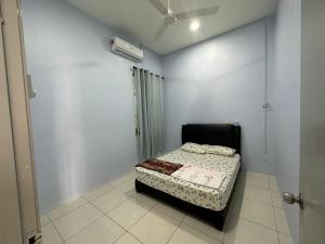 ein kleines Schlafzimmer mit einem Bett in einem Zimmer in der Unterkunft Homestay Cermai Indah Guar Chempedak in Guar Chempedak