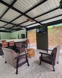 a room with chairs and a bar with a television at DS House in Cabuya