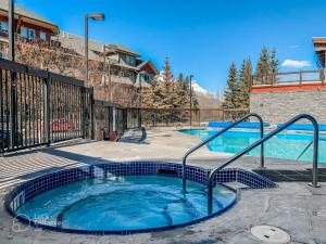 a swimming pool with a hot tub in a building at Rocky Mountain Getaway with Outdoor Heated Pool, 3 Hot Tubs, Gym, BBQ, Garage & 24 hour Reception near Banff in Canmore