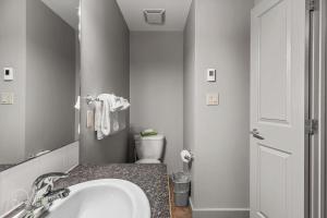 a bathroom with a sink and a toilet in it at 2BR Condo in Canmore [Pool, 3 Hot Tubs, Gym & BBQ] in Canmore