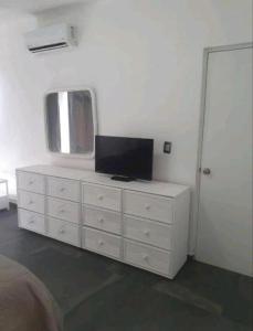 een witte dressoir met een televisie erop bij DPTO. A orilla del Mar in Manzanillo