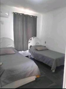 een kamer met 2 bedden en een raam bij DPTO. A orilla del Mar in Manzanillo