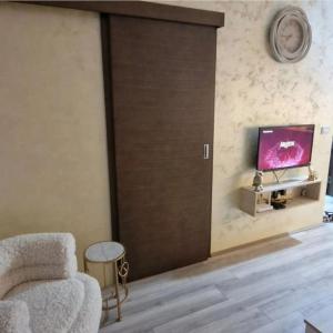 a living room with a sliding door with a tv at cocoluxapartmanl73 in Trnava