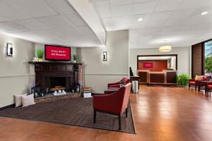 una sala de espera con chimenea y TV en Red Roof Inn Norwich, en Norwich