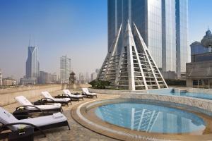a swimming pool with lounge chairs and a building at JW Marriott Shanghai at Tomorrow Square in Shanghai
