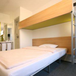 ein Schlafzimmer mit einem Etagenbett mit einer Leiter in der Unterkunft ibis budget Aachen Nord in Aachen