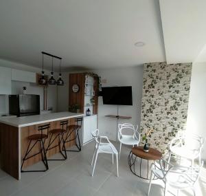 - une cuisine avec un comptoir et des chaises dans la chambre dans l'établissement Apartamentos Avenida del malecón, frente al lago. Guatape, à Guatapé