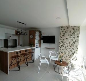 a kitchen with a counter and chairs in a room at Apartamentos Avenida del malecón, frente al lago. Guatape in Guatapé
