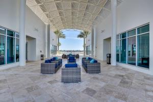 un vestíbulo con sofás, palmeras y techo en Luxe Resort Condo - 2 Mi to Daytona Beach! en Holly Hill