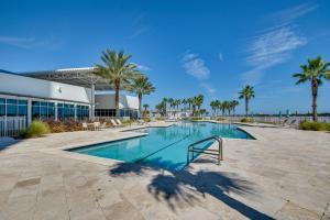 una piscina con palmeras y un edificio en Luxe Resort Condo - 2 Mi to Daytona Beach! en Holly Hill