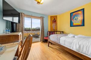 een slaapkamer met een bed en een balkon bij Qupqugiaq Inn in Anchorage
