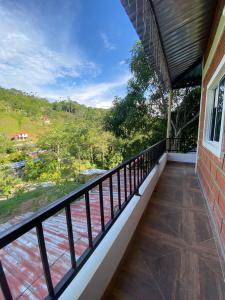 een balkon met uitzicht op het water bij CASA CAMPESTRE BELLO AMANECER in Puerto Triunfo