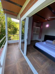 a bedroom with a bed and a balcony at CASA CAMPESTRE BELLO AMANECER in Puerto Triunfo