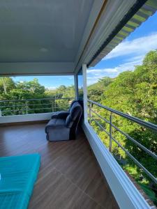 a balcony with a couch and a view of the forest at CASA CAMPESTRE BELLO AMANECER in Puerto Triunfo
