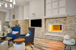 芝加哥Homewood Suites by Hilton Chicago-Downtown的大厅里有壁炉、椅子和电视