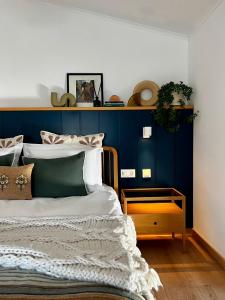 1 dormitorio con 1 cama con pared azul en Viva! Farmhouse en Monsaraz