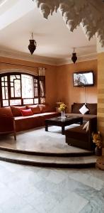 een woonkamer met een bank en een tafel bij maison d'hôtes Le petit jardin Marrakech in Marrakesh
