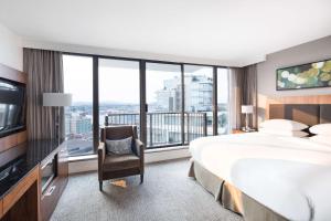 a hotel room with a large bed and a television at DoubleTree by Hilton Hotel & Suites Victoria in Victoria