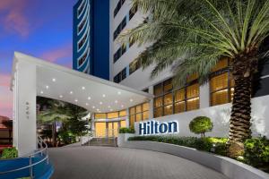 a building with a palm tree in front of it at Hilton Cabana Miami Beach Resort in Miami Beach