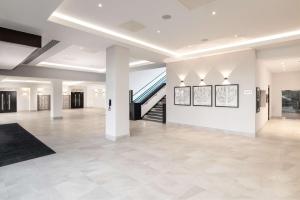 Cette grande chambre est dotée de murs blancs et d'un escalier. dans l'établissement Hilton London Gatwick Airport, à Horley