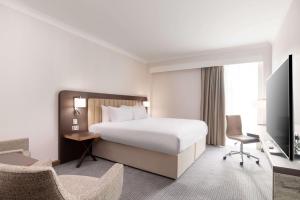 a hotel room with a bed and a tv at Hilton London Gatwick Airport in Horley