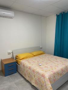 a bedroom with a bed and a blue curtain at Casa Ilaria in Elmas