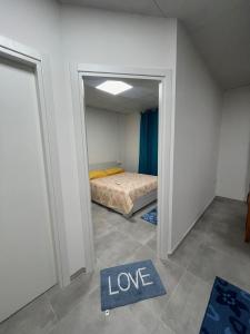 una piccola stanza con un letto e un cartello che dice amore di Casa Ilaria a Elmas