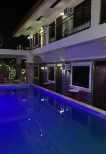 a large swimming pool in front of a building at night at Bountiful Inn in Puerto Princesa City