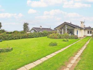 a yard with green grass and a house at Three-Bedroom Holiday home in Faaborg 3 in Faaborg