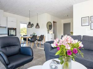 ein Wohnzimmer mit einer Blumenvase auf dem Tisch in der Unterkunft Holiday home Ringkøbing LXXX in Ringkøbing