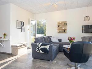 ein Wohnzimmer mit einem Sofa und einem Stuhl in der Unterkunft Holiday home Ringkøbing LXXX in Ringkøbing