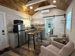 a kitchen and living room in a tiny house at Blissful Nook Tiny Home ~ Cozy Retreat w/ Hot Tub; near Town and Deep Creek in Bryson City