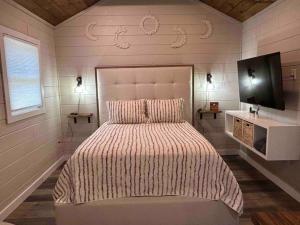 sypialnia z dużym łóżkiem i telewizorem w obiekcie Blissful Nook Tiny Home ~ Cozy Retreat w/ Hot Tub; near Town and Deep Creek w mieście Bryson City