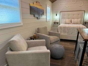 a living room with a couch and a bed at Blissful Nook Tiny Home ~ Cozy Retreat w/ Hot Tub; near Town and Deep Creek in Bryson City