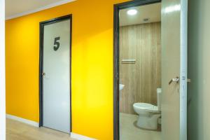a bathroom with a toilet and a yellow wall at Amanecer de la Bahía in Ushuaia