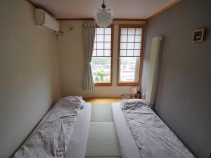um quarto com 2 camas e uma janela em 民泊森の家 em Moiwashita
