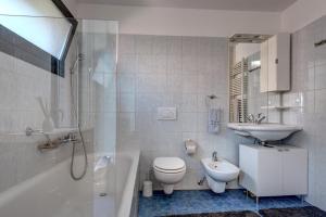 łazienka z toaletą, umywalką i wanną w obiekcie Casa Oliver, tra la Calanca e i castelli di Bellinzona w mieście Grono