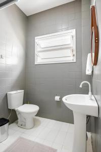 un bagno bianco con un water e un lavandino di Casa 215 Suítes pertinho da Praia a Balneário Camboriú