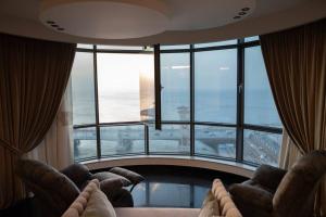 - un salon avec des chaises et une grande fenêtre dans l'établissement شقة فندقيه للايجار شاطئ ستانلي, à Alexandrie