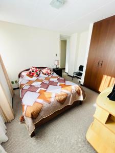 1 dormitorio con 1 cama con edredón en Confortable y Amplio Apartamento Duplex en zona céntrica de Calacoto, en La Paz