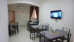 a dining room with tables and chairs and a flat screen tv at Crystal Premier Hotel in Pantang