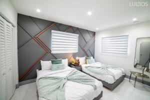 deux lits dans une chambre avec un mur dans l'établissement Cozy paradise, with heated pool, near Airport in Miami L16, à Miami 34 autres photos