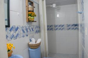 a bathroom with a shower with blue and white tiles at Apartamento Rincon sereno in Medellín